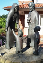 Bronzeskulptur  an der Dorfkirche:
 Mutter M. Anselma  und Pfarrer Dall  mit Kindern
